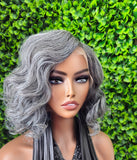 Mannequin head with gray wig against a green leafy background