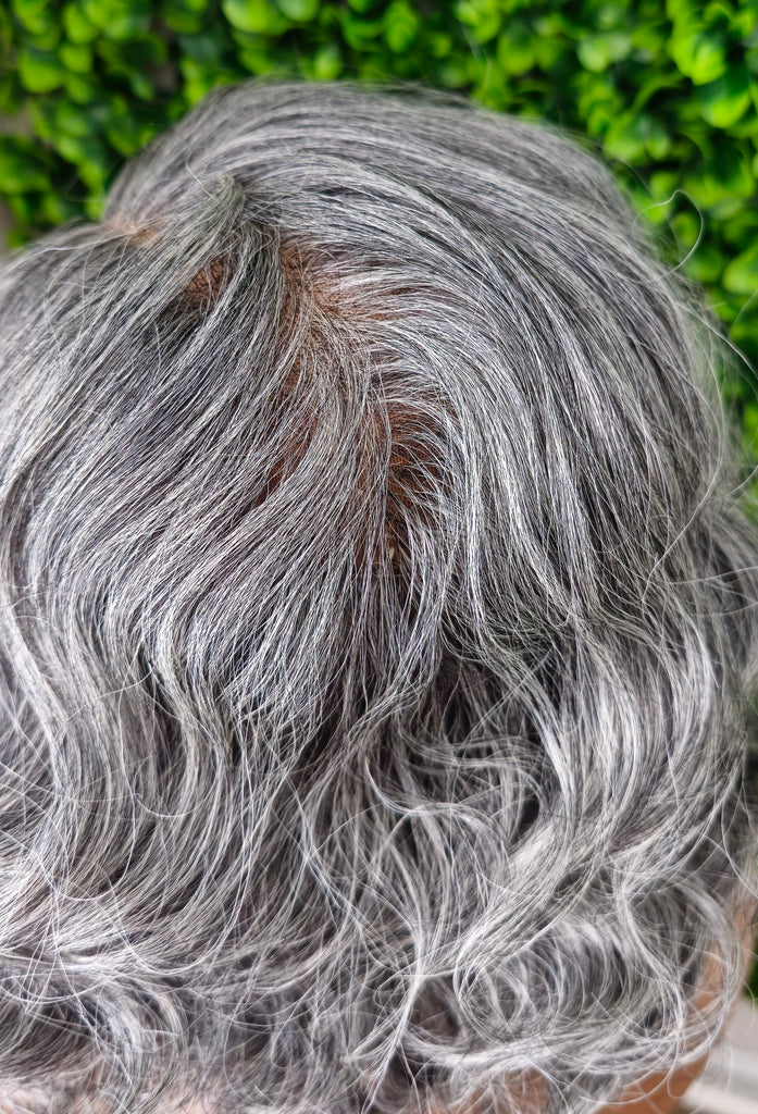 Close-up of gray hair with a blurred green background