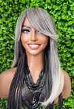  gray and black ombre wig against a green leafy background